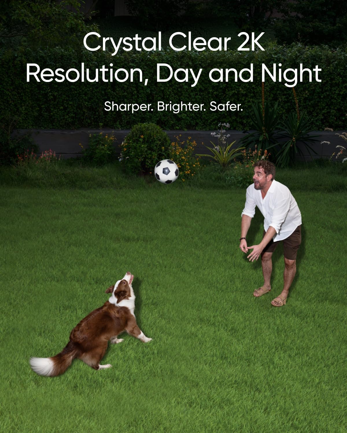 Man playing with dog at night in garden, illuminated by security floodlight with 2K resolution camera for crystal-clear video